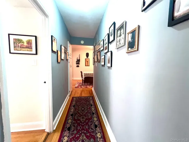 a hallway with painting on the wall and a window