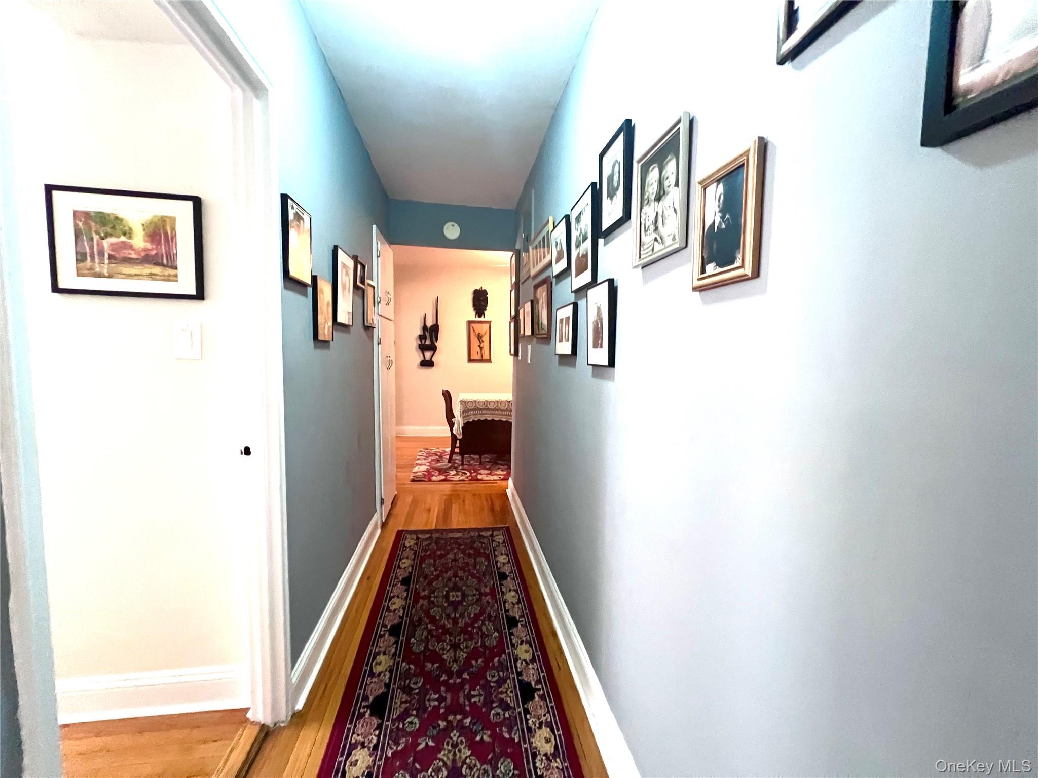 2080 Barnes Avenue, Unit 5C Bronx, NY 10462 - Photo 6 of 13 a hallway with painting on the wall and a window