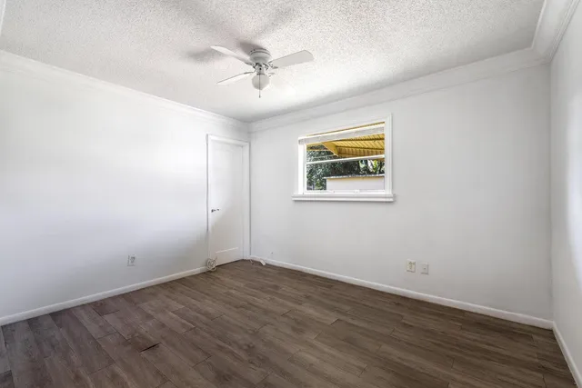 a view of empty room with wooden floor