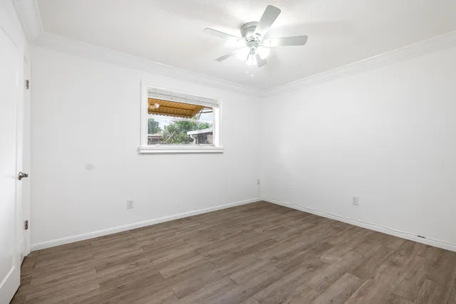 an empty room with wooden floor and window