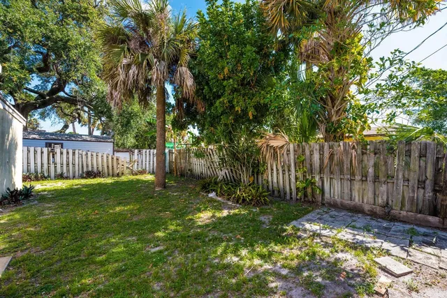 a view of a yard with wooden fence and trees