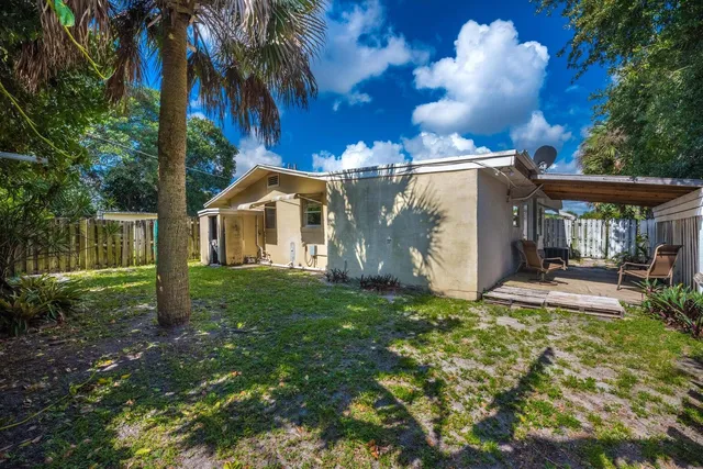 a view of a house with backyard and sitting area