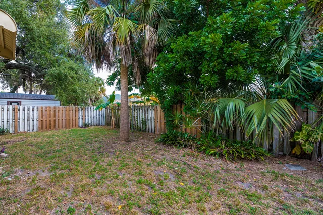 a view of a yard with wooden fence