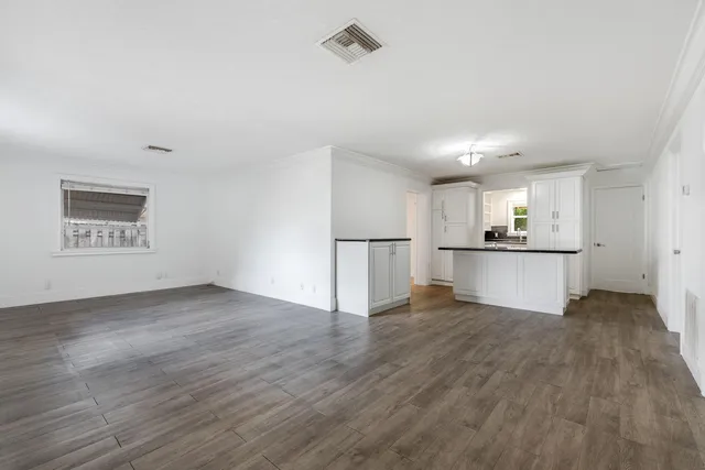 a view of a kitchen with a fridge and wooden floor