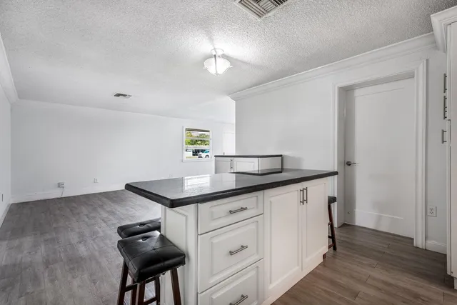 a kitchen with cabinets table and chairs