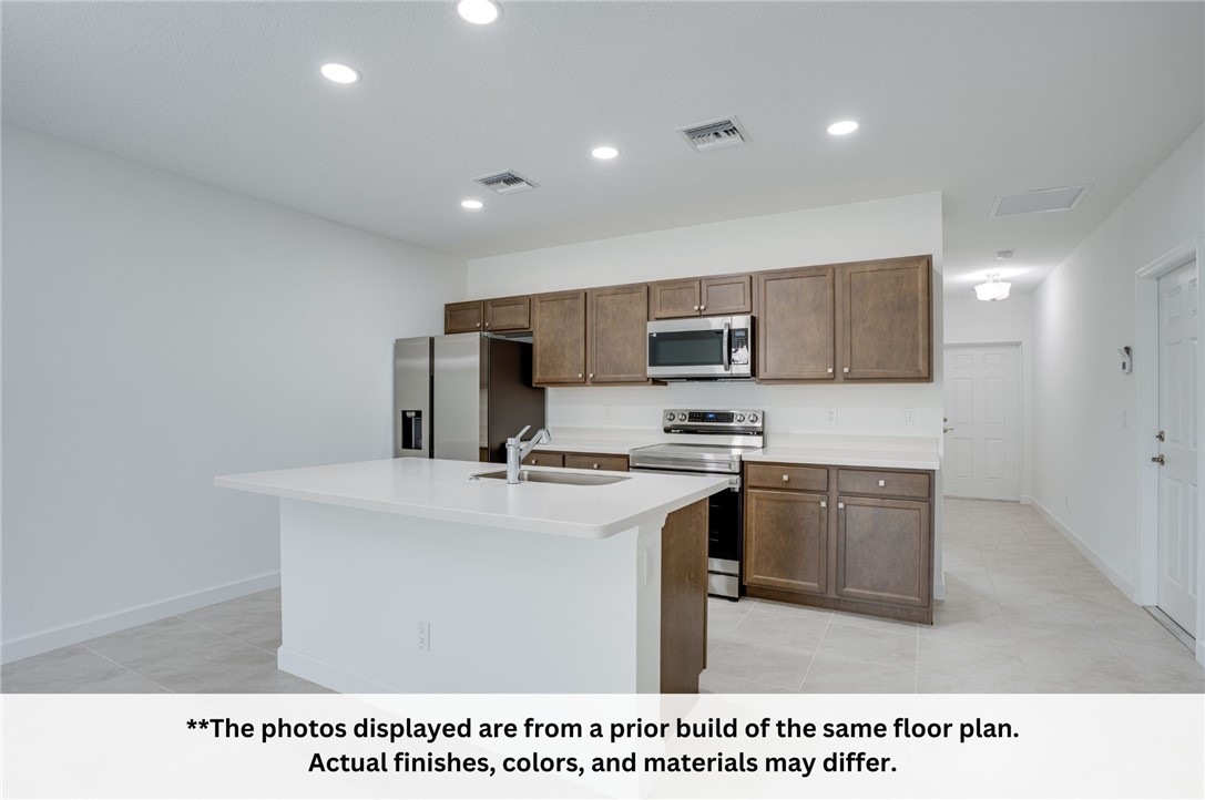 125 Admiral Circle Sebastian, FL 32958 - Photo 10 of 19 a kitchen with kitchen island a sink appliances and cabinets
