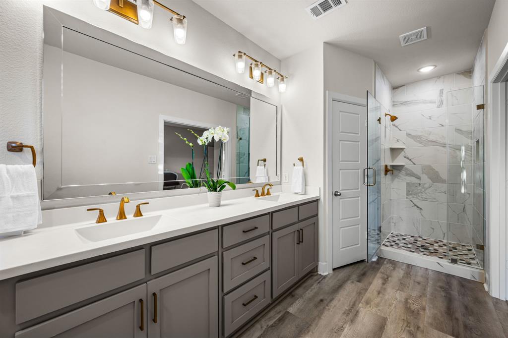 5325 Autumnbrook Court Dallas, TX 75209 - Photo 18 of 38 a bathroom with a double vanity sink a mirror a shower and a bathtub