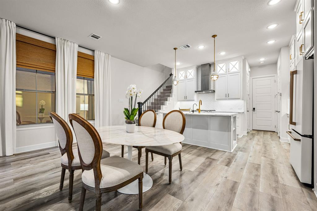 5325 Autumnbrook Court Dallas, TX 75209 - Photo 8 of 38 a dining room with furniture a flat screen tv and wooden floor