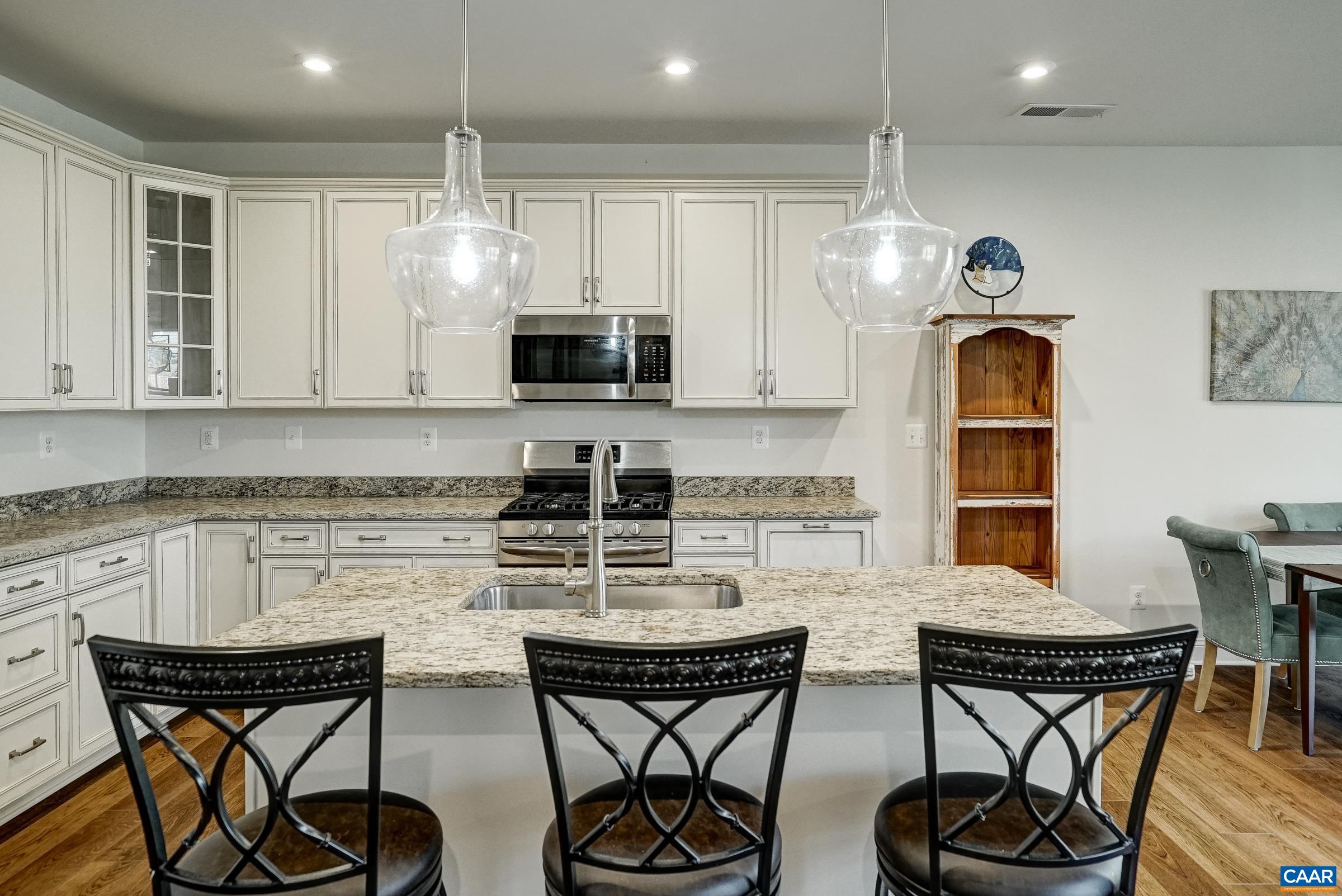 146 Timber Ridge Lane Zion Crossroads, VA 22942 - Photo 11 of 31 a kitchen with stainless steel appliances kitchen island granite countertop a dining table chairs and white cabinets