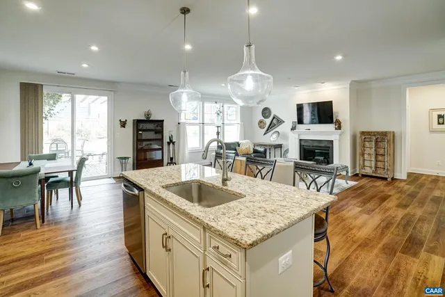 a kitchen with stainless steel appliances granite countertop a sink a stove and a wooden floors