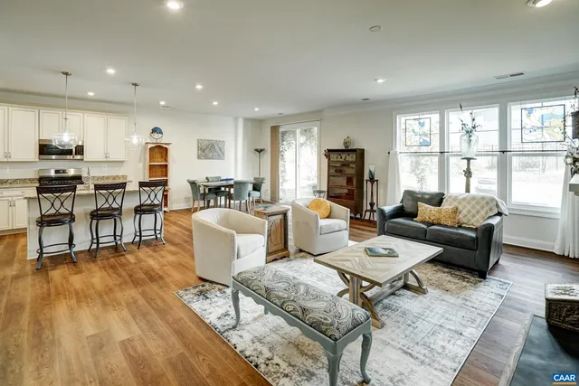 a living room with furniture wooden floor and a large window