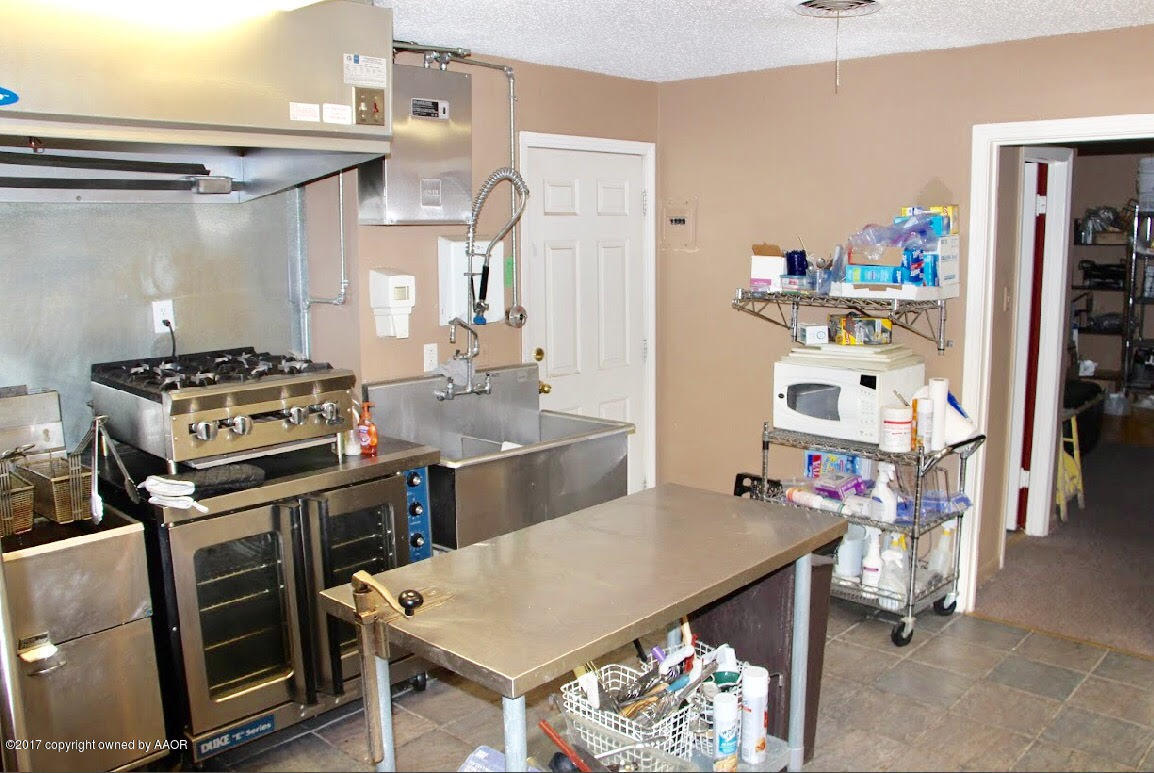 4118 South Washington Street Amarillo, TX 79110 - Photo 16 of 18 a kitchen with stainless steel appliances a stove a table and chairs