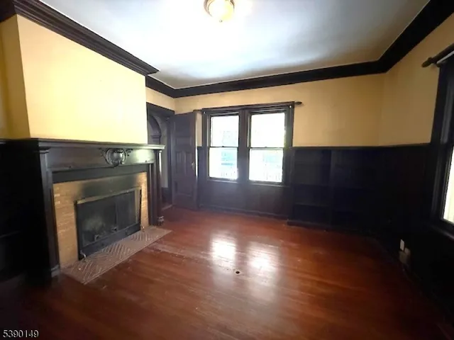 a view of an empty room with a fireplace and a window