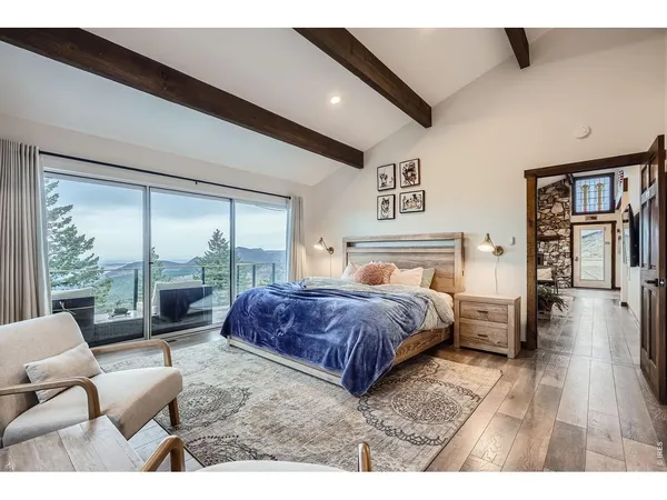 a spacious bedroom with a bed a couch and large window