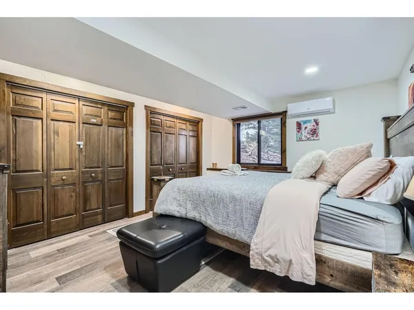 a bedroom with a bed and wooden floor