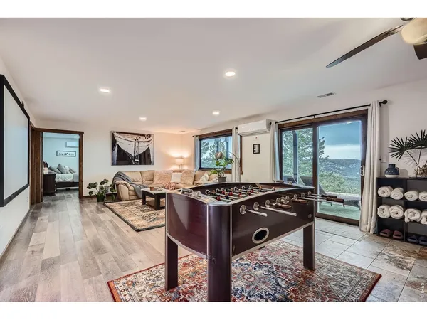 a living room with furniture a flat screen tv and a floor to ceiling window