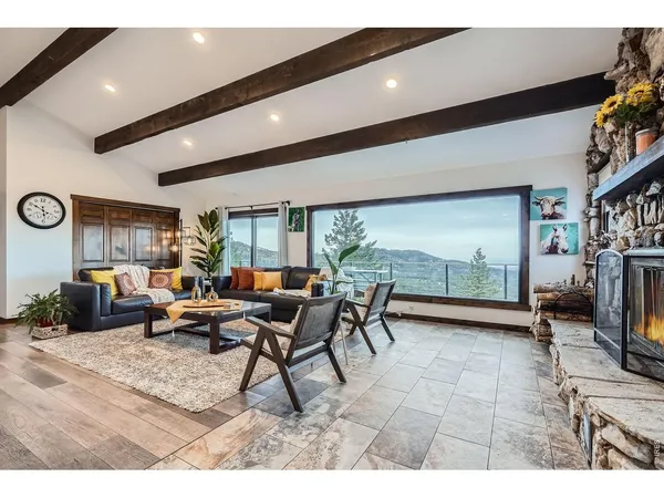 a living room with furniture a floor to ceiling window and a flat screen tv