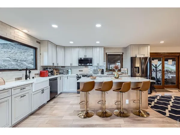 a kitchen with stainless steel appliances kitchen island granite countertop a stove and a sink