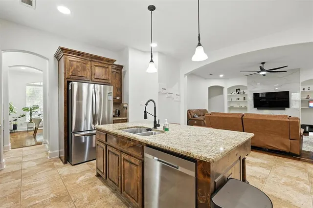 a kitchen with stainless steel appliances granite countertop a kitchen island a stove and a sink