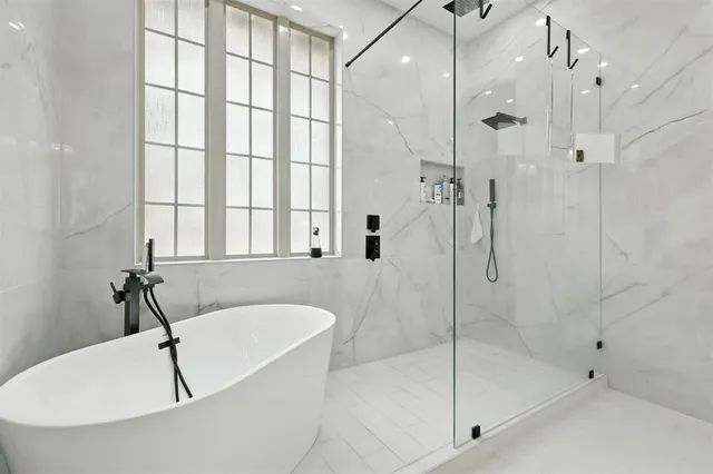 a white bath tub sitting next to a shower