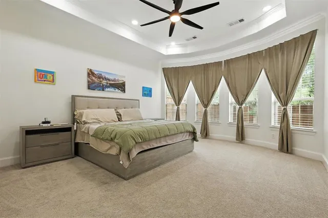 a spacious bedroom with a bed and a painting on the wall