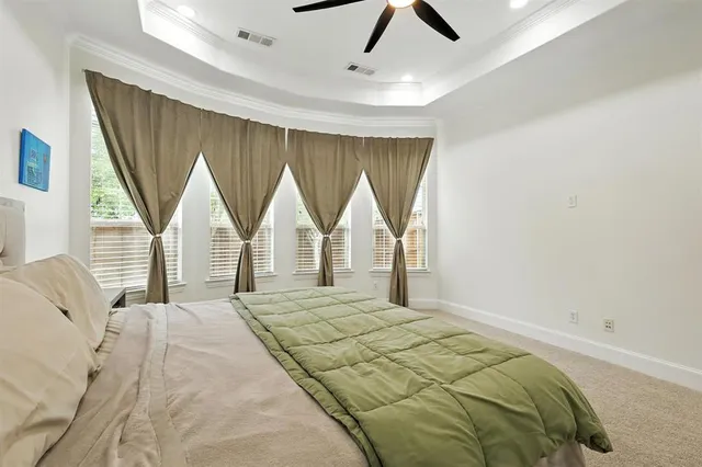 a bedroom with a bed windows and a chandelier