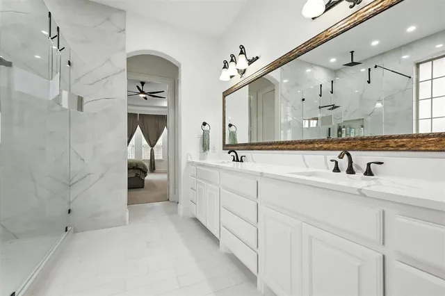 a spacious bathroom with a double vanity sink mirror and shower