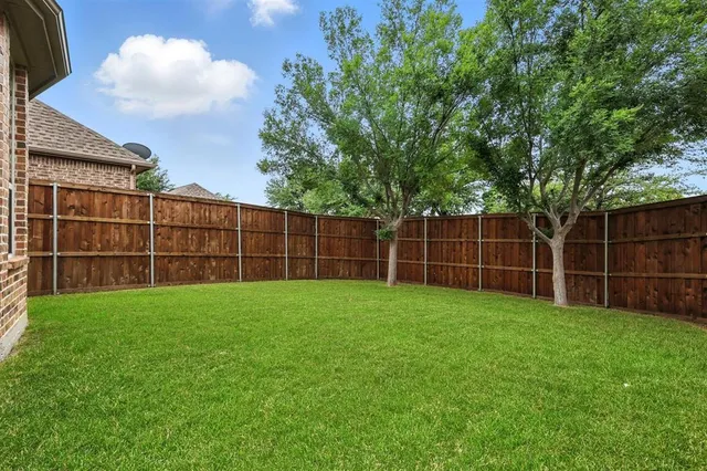 a view of a yard with a wooden fence