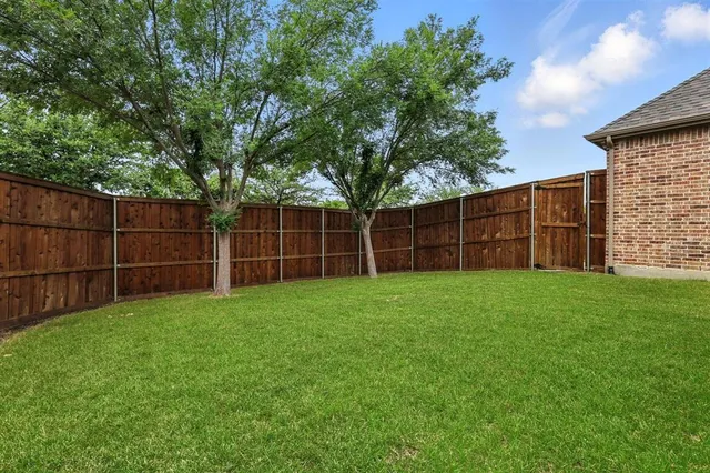 a view of a backyard with a wooden fence