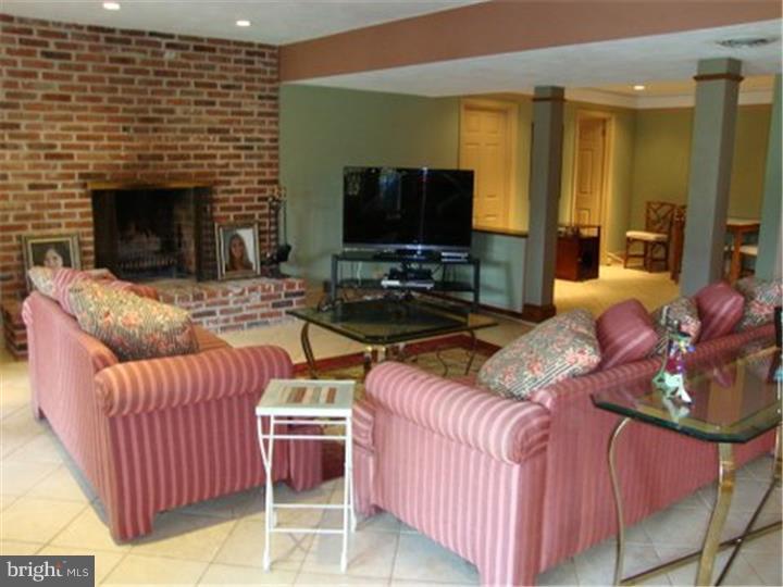 1314 Youngs Ford Road Gladwyne, PA 19035 - Photo 16 of 22 a living room with furniture a flat screen tv and a fireplace