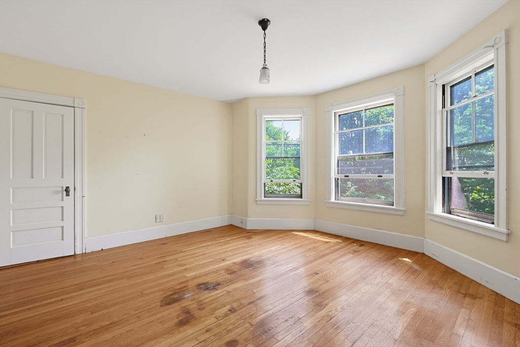 7 Baker Street Worcester, MA 01603 - Photo 34 of 42 an empty room with wooden floor and windows
