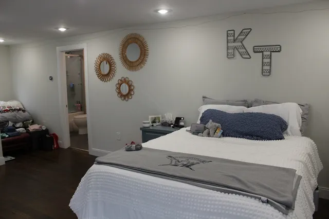 a bedroom with a bed and painting on the wall