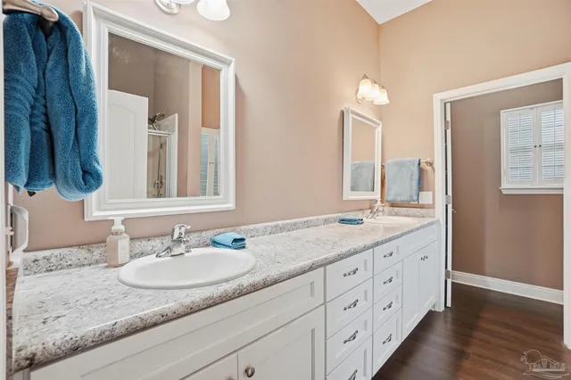 a bathroom with a granite countertop sink double and mirror