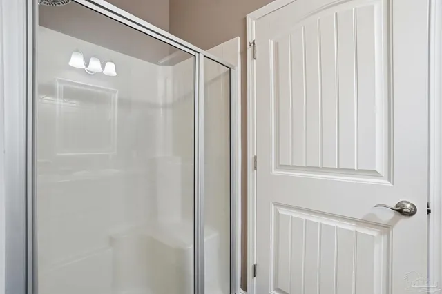 a bathroom with a glass shower door and a shower