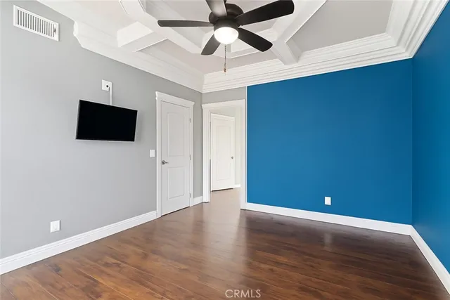a view of a livingroom with wooden floor and a ceiling fan