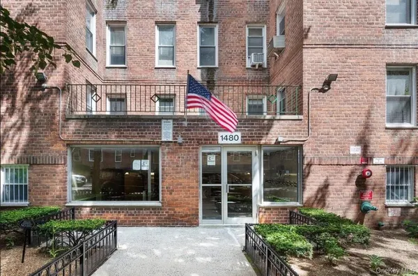 front view of a brick building with a small yard