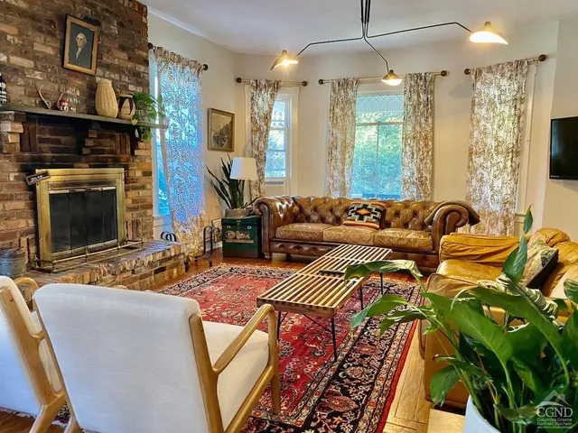 a living room with furniture a flat screen tv and a fireplace