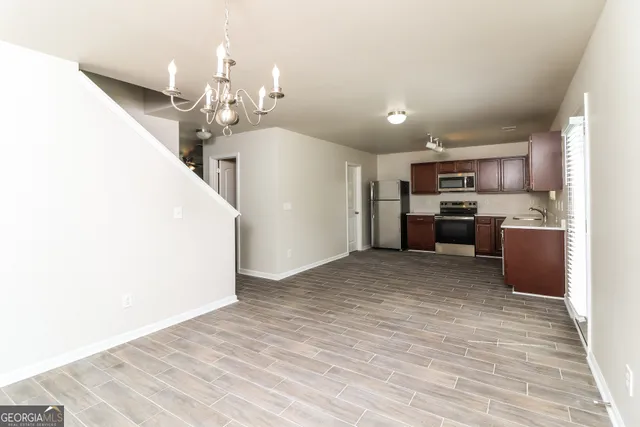 a view of a kitchen with kitchen island wooden floor center island and stainless steel appliances