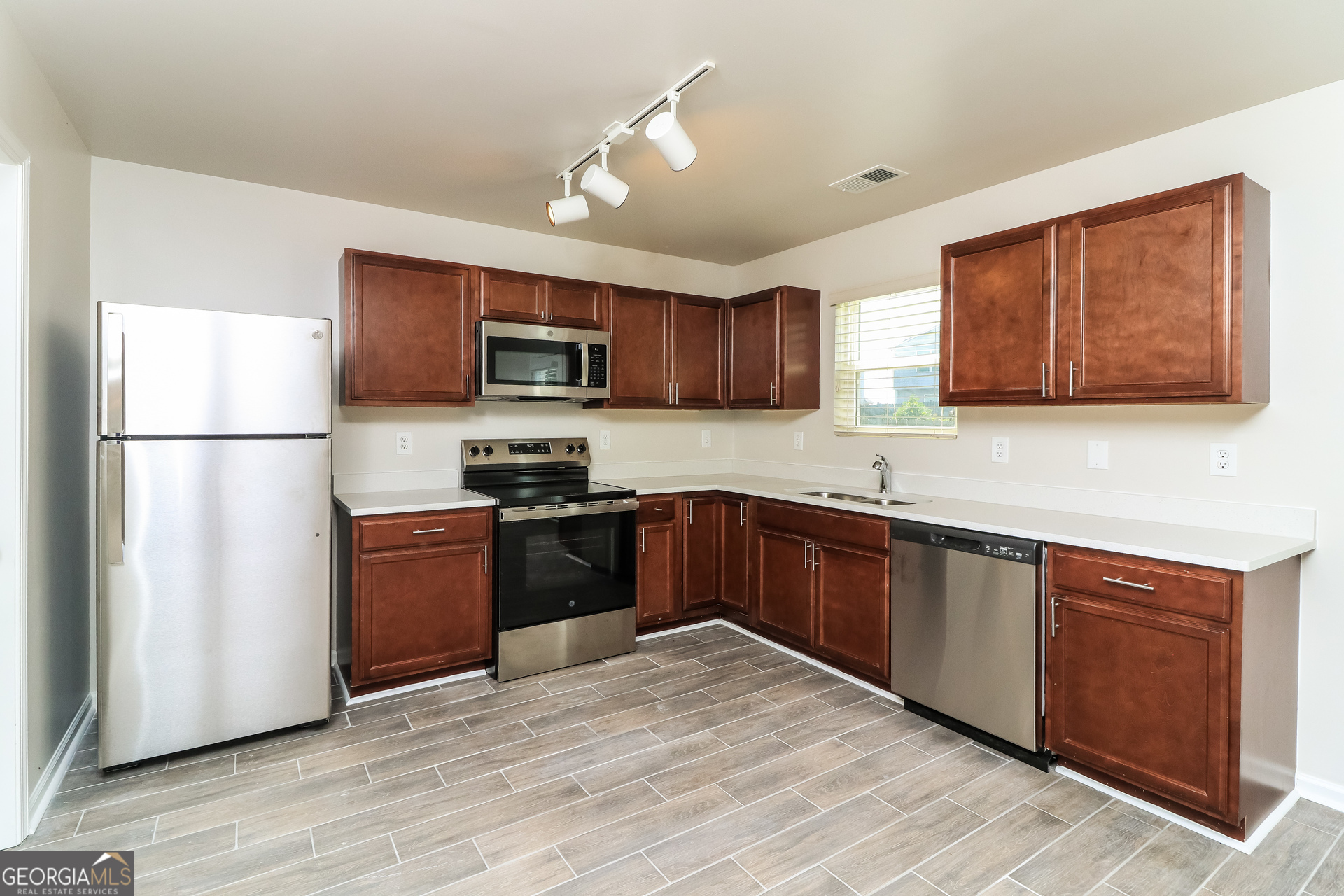 404 Scenic View Court Villa Rica, GA 30180 - Photo 9 of 17 a kitchen with granite countertop wooden cabinets a refrigerator a sink a stove a microwave and wooden floors