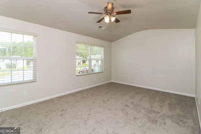 an empty room with a window and a fan