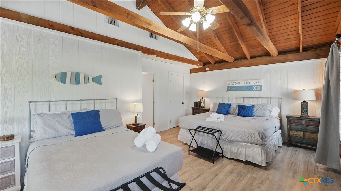 205 Bravo Road Canyon Lake, TX 78133 - Photo 18 of 38 a bedroom with a bed and a chandelier