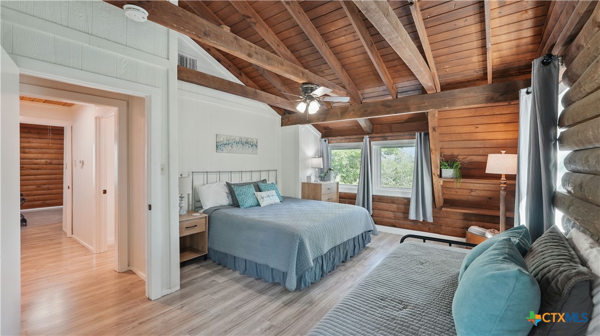 205 Bravo Road Canyon Lake, TX 78133 - Photo 21 of 38 a bedroom with a large bed and a large window with balcony