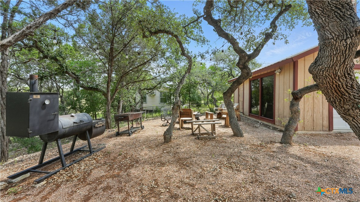 205 Bravo Road Canyon Lake, TX 78133 - Photo 26 of 38 a backyard of a house with table and chairs