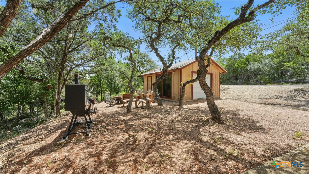 205 Bravo Road Canyon Lake, TX 78133 - Photo 28 of 38 a backyard of a house with table and chairs