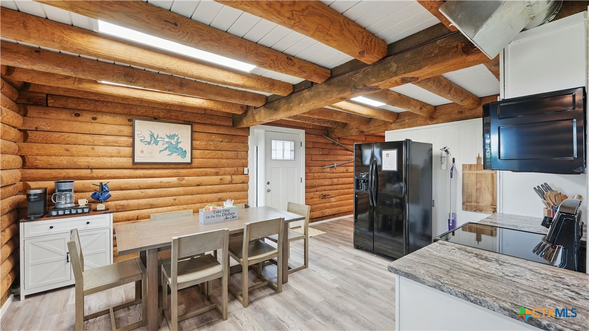 205 Bravo Road Canyon Lake, TX 78133 - Photo 5 of 38 a kitchen with stainless steel appliances kitchen island granite countertop a table chairs in it and wooden floors