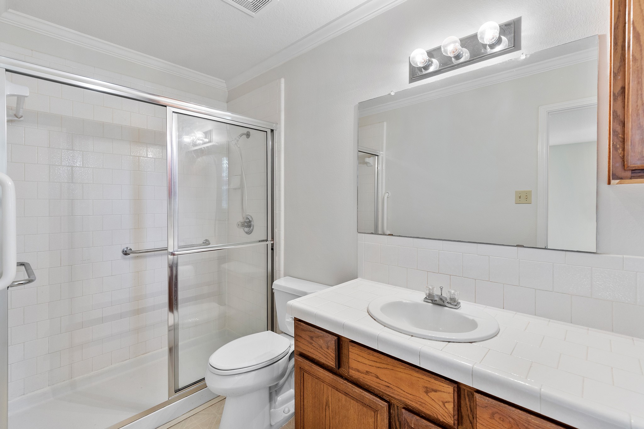 8018 Holiday Lane Houston, TX 77075 - Photo 24 of 42 a bathroom with a shower sink vanity mirror and toilet