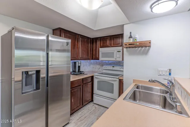 a kitchen with stainless steel appliances granite countertop a refrigerator stove microwave and sink