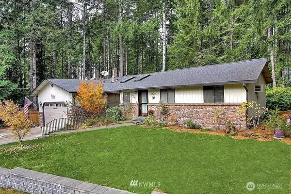 a front view of a house with a garden and trees