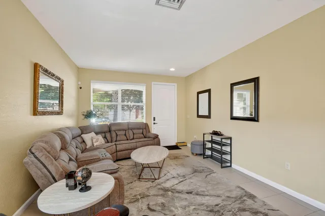 a living room with furniture a large window and a dining table