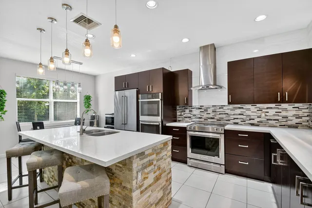 a kitchen with stainless steel appliances granite countertop a stove a refrigerator and a microwave